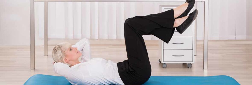 woman doing floor exercises in her office