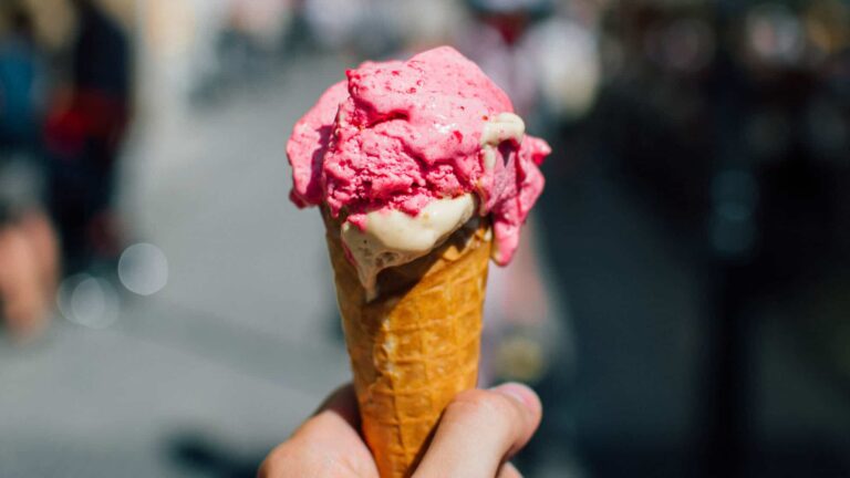 Hand holding a pink ice cream cone