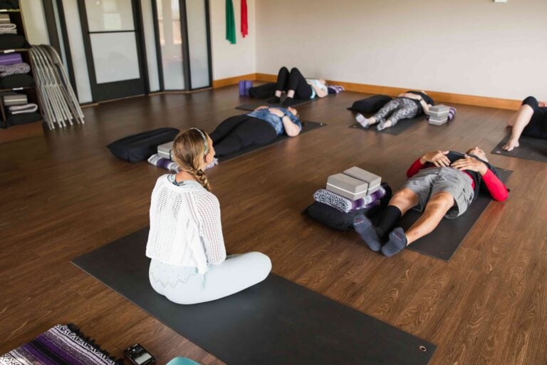 Guests resting on yoga mats during a quiet restorative class