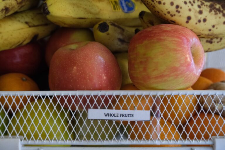 Basket of whole fruits including apples, bananas and oranges