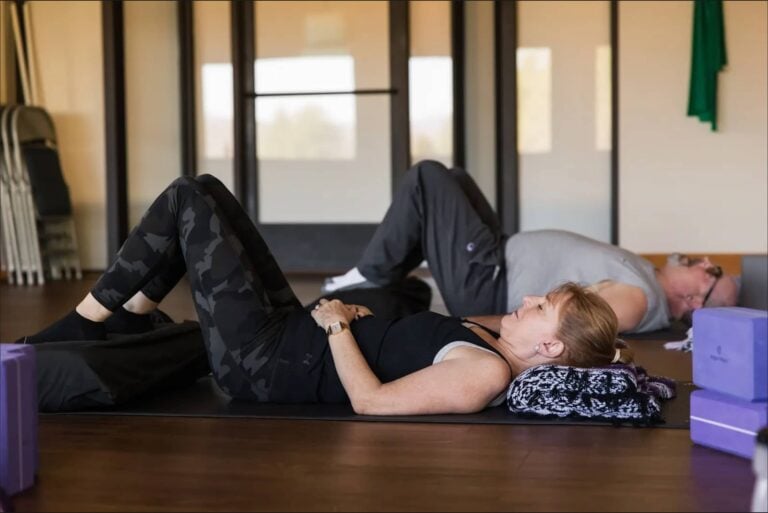Guests lying on bolsters during a guided relaxation class