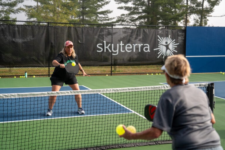 Guests rallying on the outdoor pickleball courts