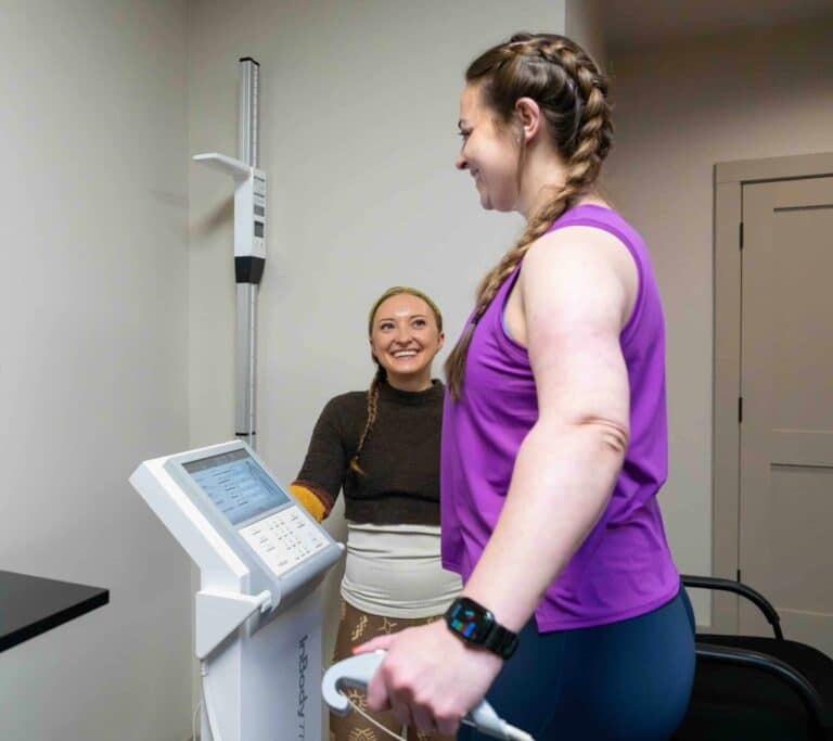 Guest stepping onto an InBody scanner while a Skyterra team member looks on